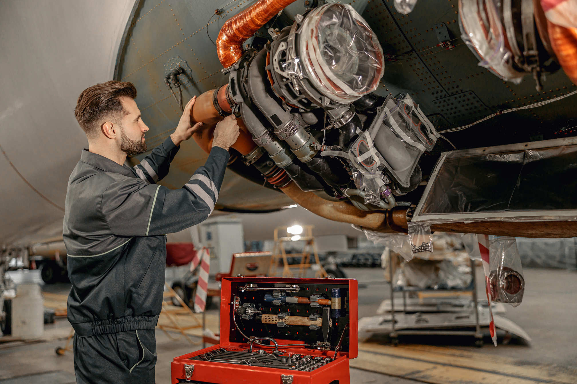 Male Aviation Mechanic Repairing Airplane in Hangar